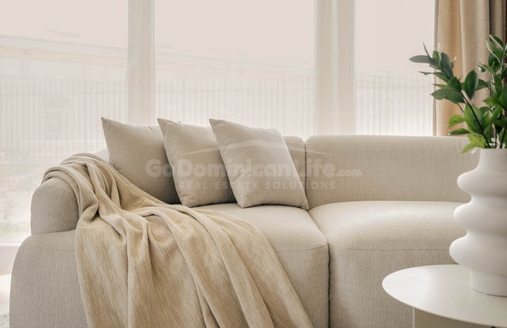 Three,Grey,Pillows,And,Blanket,On,Grey,Soft,Sofa,In